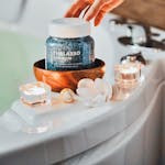 A cozy bath setup with bath salts, candles, and a serene atmosphere for relaxation.